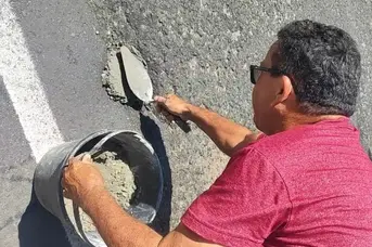 Buraco em avenida provoca acidente e morador faz reparo por conta própria